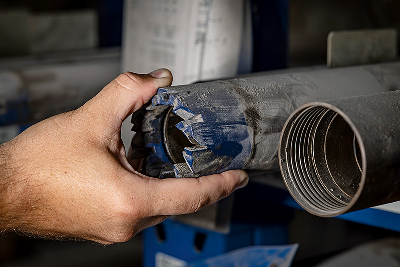 Eine Hand berührt eines von zwei Rohren aus Metall.