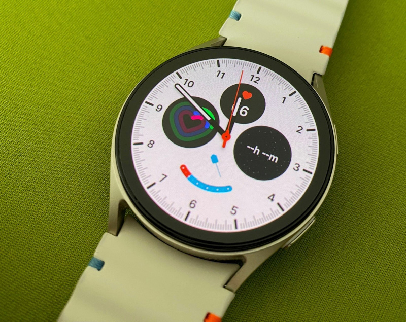 Foto des digitalen Ziffernblatts einer silberfarbenen Smartwatch auf grünem Hintergrund.